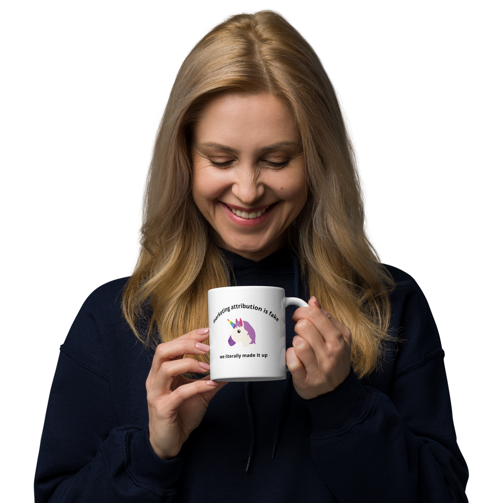 woman holding Marketing Attribution Is Fake News Mug in left hand